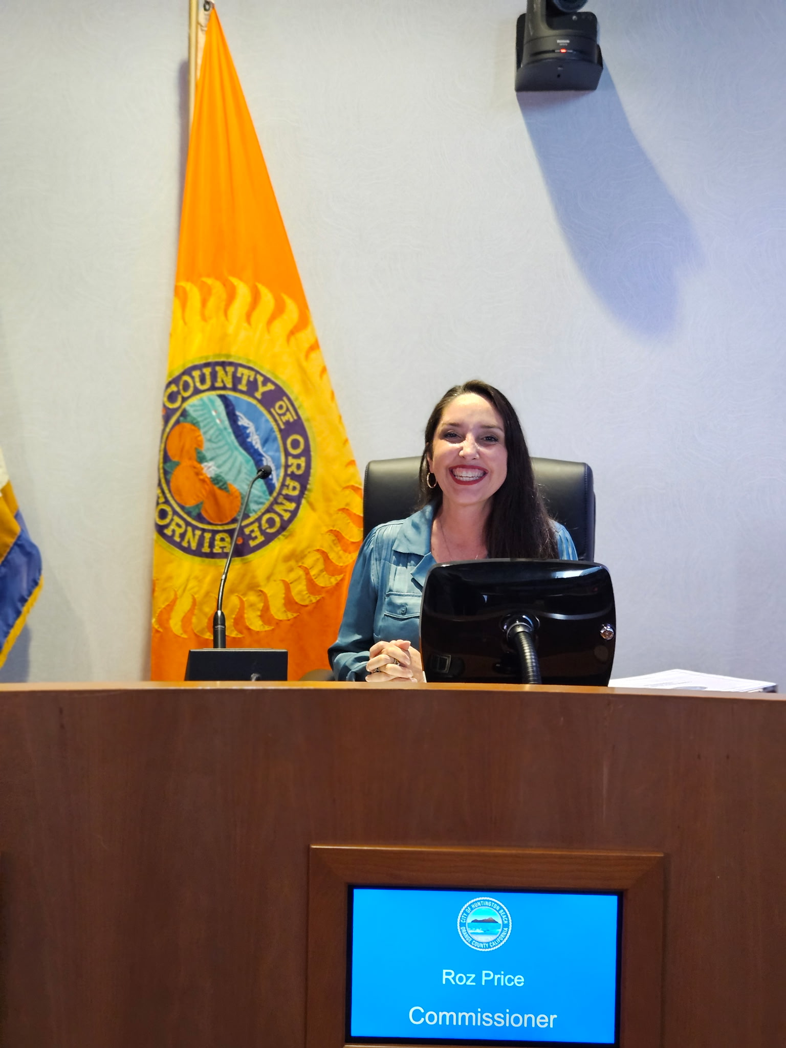 Roz Price seated at the dais as a commissioner