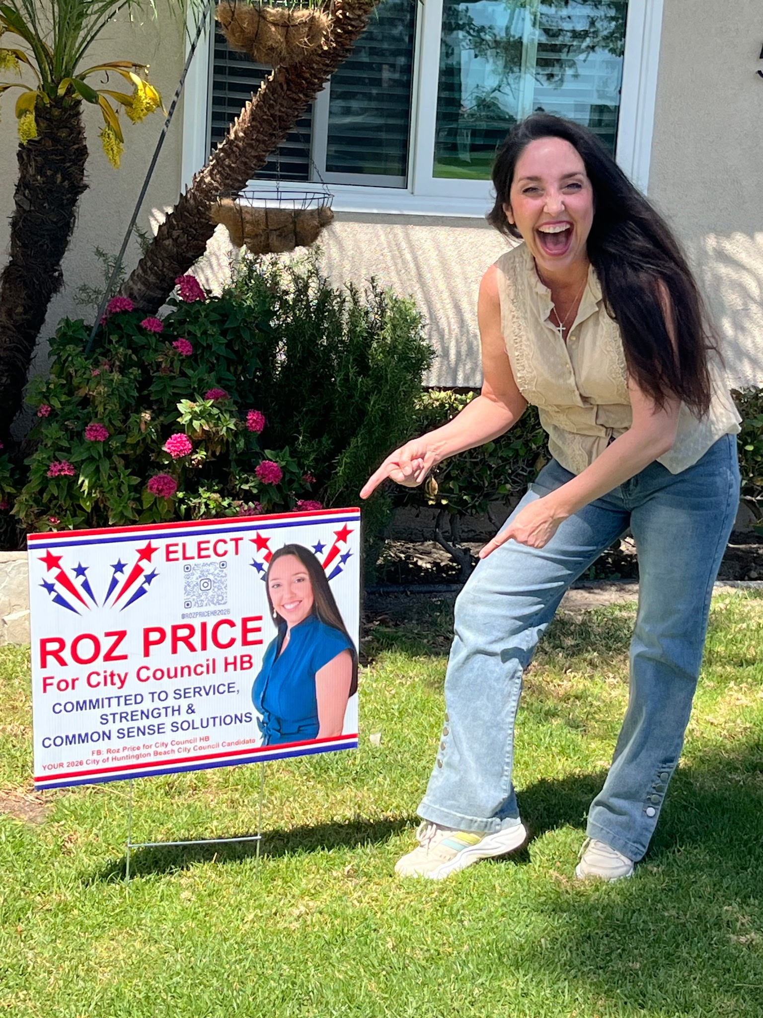 Roz Price standing next to campaign yard sign in Huntington Beach